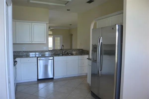 a kitchen with stainless steel appliances granite countertop a refrigerator and a stove