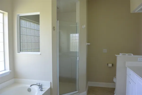 a bathroom with a granite countertop sink a toilet and shower