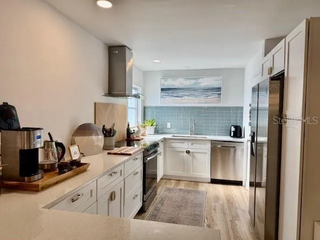 a kitchen with white cabinets and white appliances