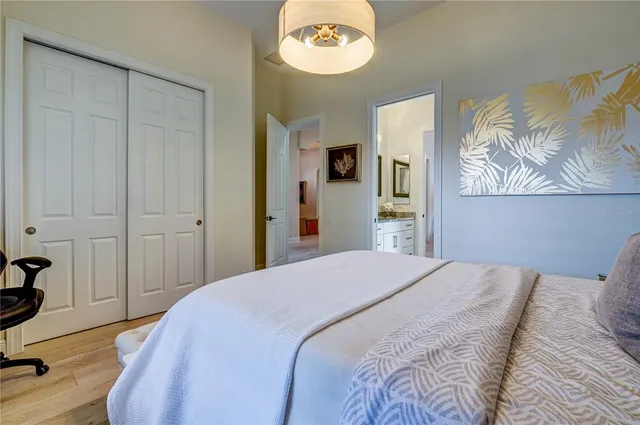 a bedroom with a bed and a chandelier