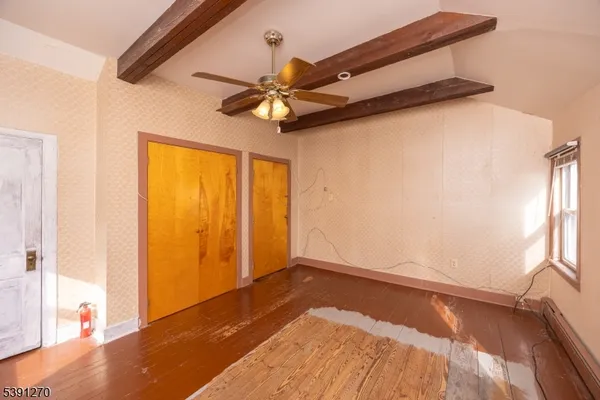 a view of a room with wooden floor and a ceiling fan