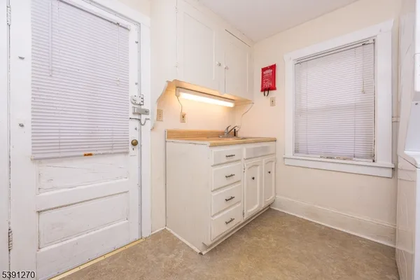 a view of a bedroom with cabinet mirror and window
