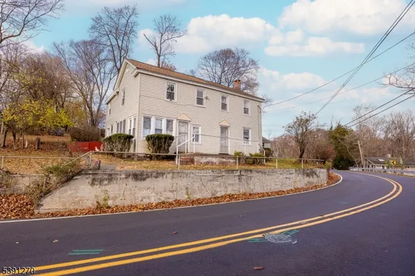 a view of a white house with a street