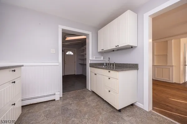 a kitchen with granite countertop white cabinets and a sink