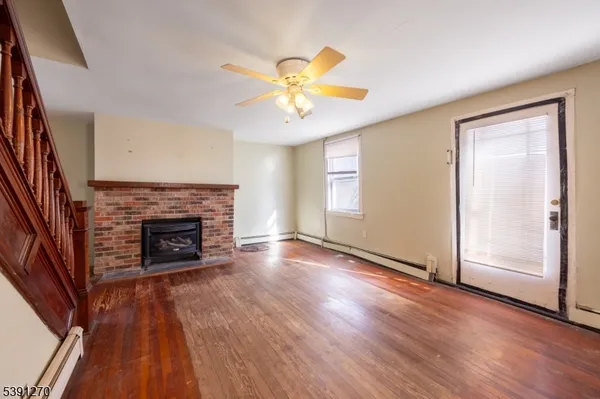 a view of an empty room with a fireplace and a window