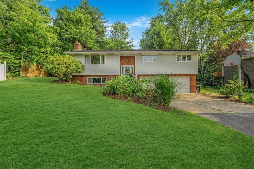 front view of house with a yard and trees
