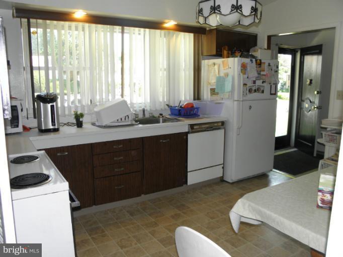 2323 Micarol Road Baltimore, MD 21209 - Photo 3 of 6 a kitchen with stainless steel appliances a sink a refrigerator and a large window