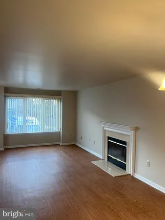 an empty room with wooden floor and fireplace