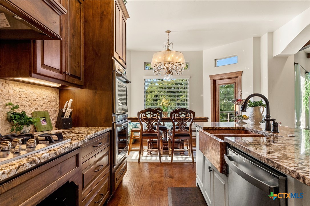 134 Bandit Beach Road New Braunfels, TX 78130 - Photo 17 of 46 a kitchen with stainless steel appliances granite countertop a stove a sink dishwasher and cabinets with wooden floor