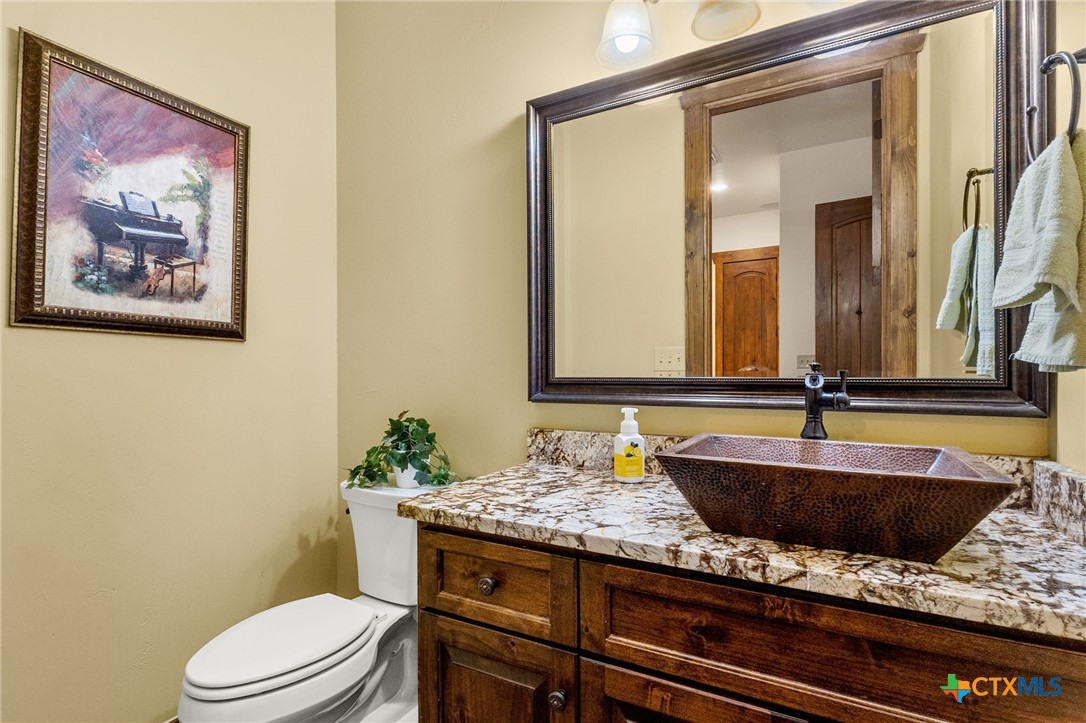 134 Bandit Beach Road New Braunfels, TX 78130 - Photo 22 of 46 a bathroom with a granite countertop sink and a mirror