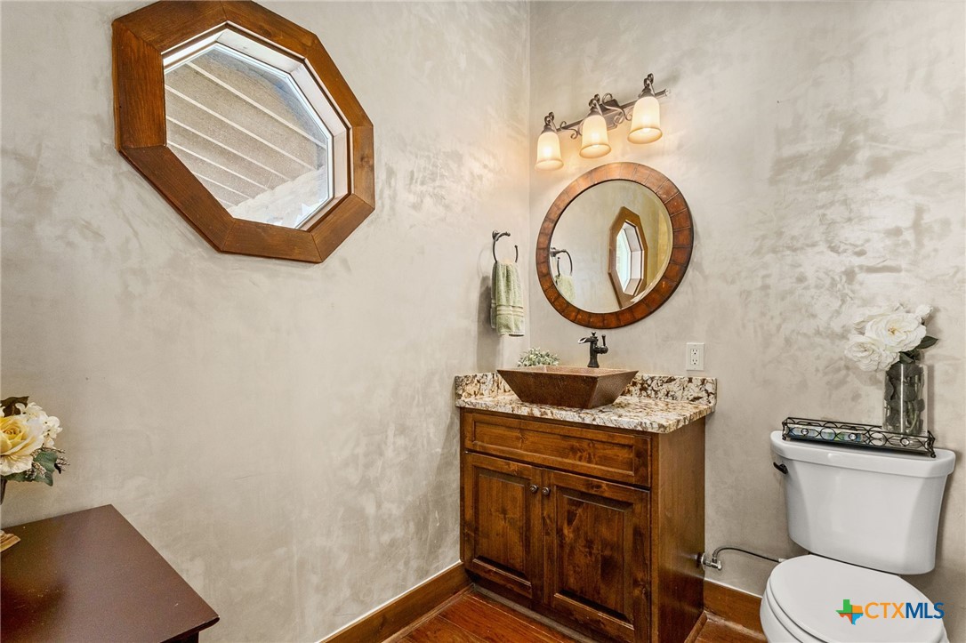 134 Bandit Beach Road New Braunfels, TX 78130 - Photo 36 of 46 a bathroom with a toilet a sink and a mirror