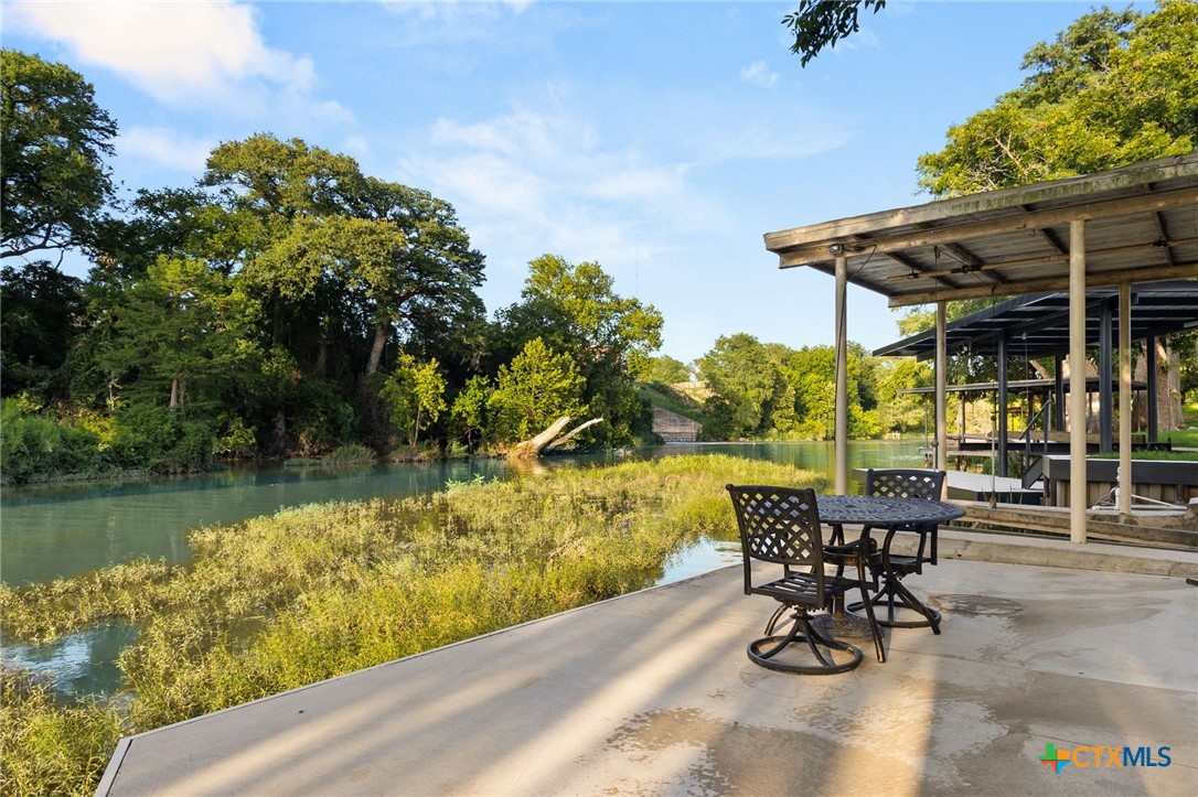 134 Bandit Beach Road New Braunfels, TX 78130 - Photo 39 of 46 a view of a lake with table and chairs under an umbrella