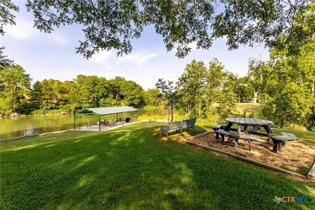 134 Bandit Beach Road New Braunfels, TX 78130 - Photo 42 of 46 a view of a lake with a yard and a large tree