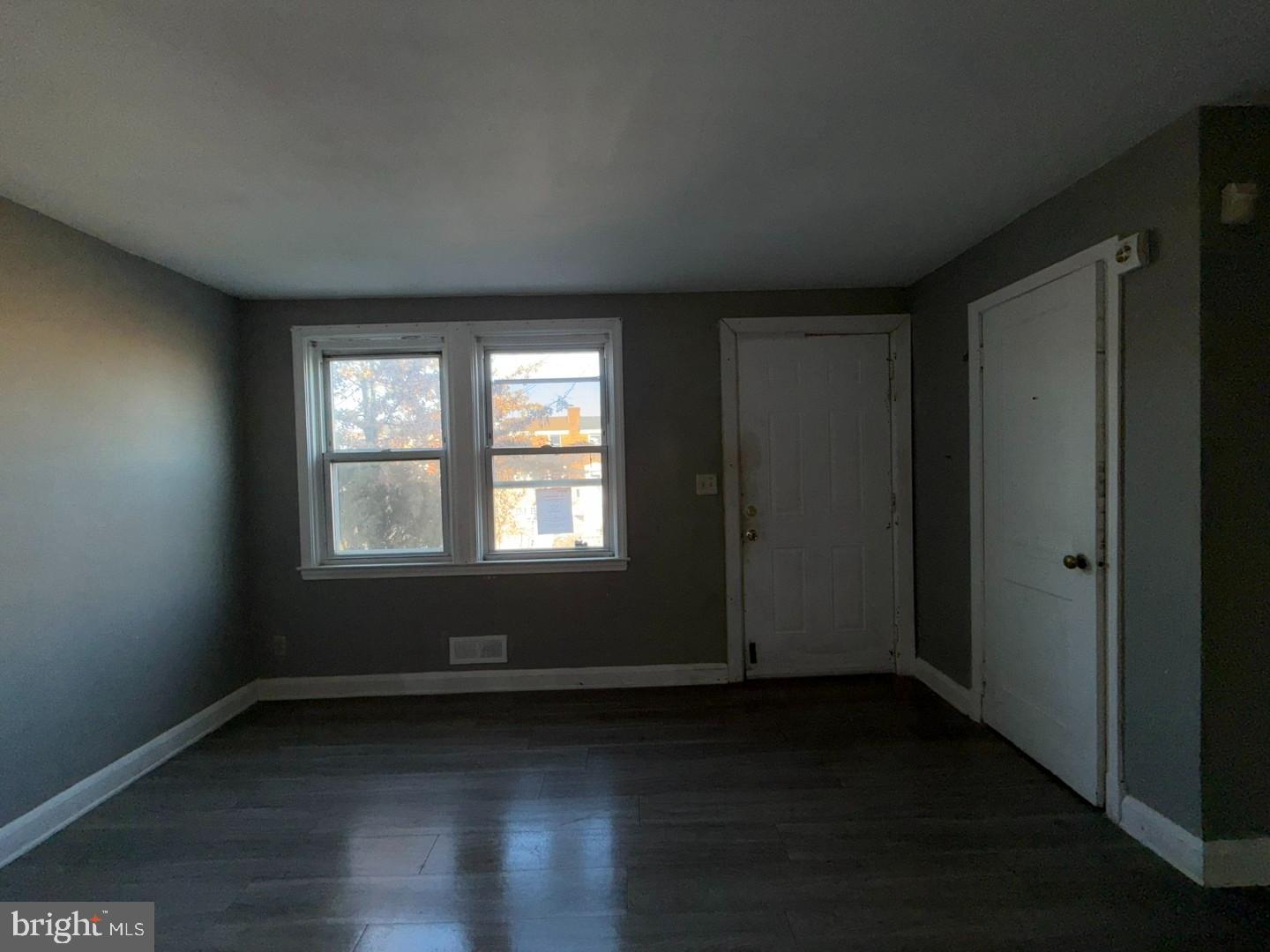 4027 Raymonn Avenue Baltimore, MD 21213 - Photo 4 of 19 an empty room with wooden floor and windows