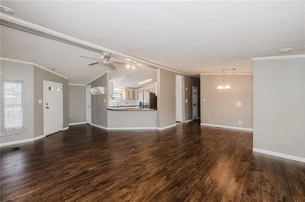 a view of an empty room with window and wooden floor