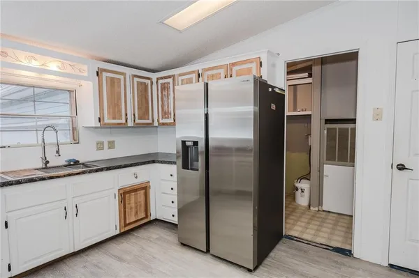 a kitchen with a refrigerator sink and cabinets
