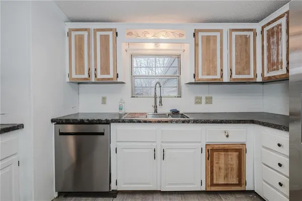 a kitchen with granite countertop white cabinets and a stainless steel appliances