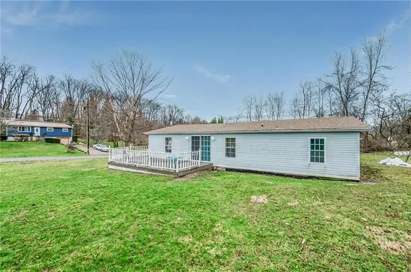 a front view of a house with a yard and trees