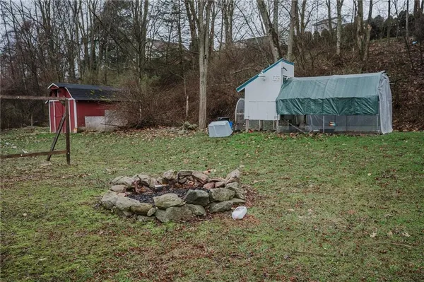 a backyard of a house with wooden fence and large trees