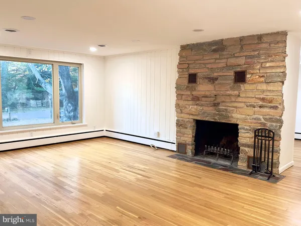 a view of a livingroom with wooden floor and a fireplace