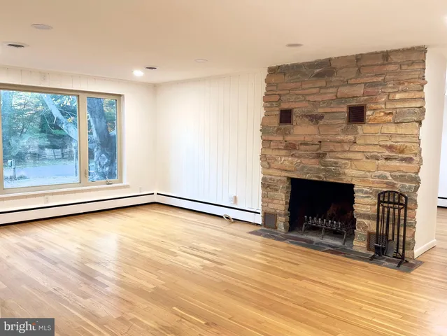 a view of a livingroom with wooden floor and a fireplace