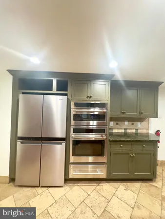 a kitchen with stainless steel appliances granite countertop a refrigerator and a sink