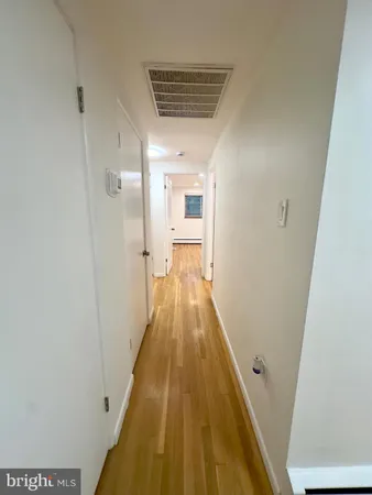 a view of a hallway with wooden floor