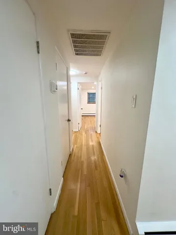 a view of a hallway with wooden floor