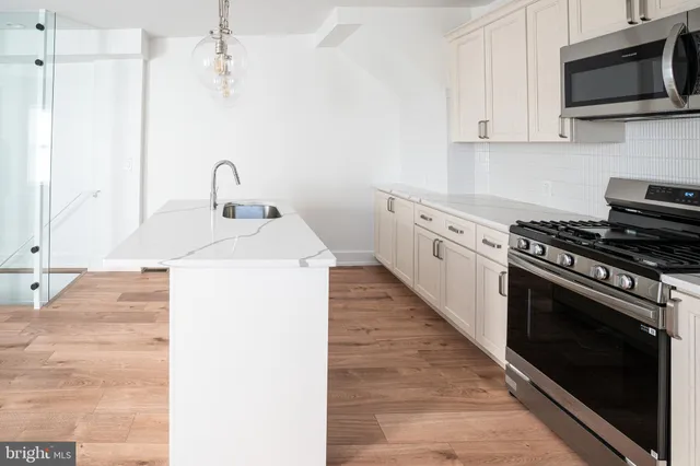 a kitchen with a sink stove and microwave