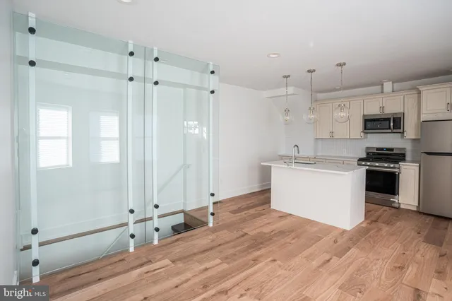 a kitchen with stainless steel appliances a refrigerator sink and white cabinets