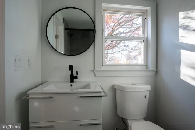 a bathroom with a toilet a sink and a window