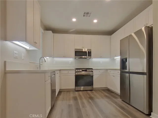 a kitchen with stainless steel appliances granite countertop a refrigerator sink and stove