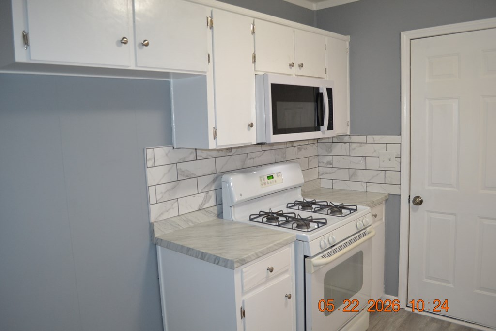 5552 Valleybrook Road Columbus, GA 31907 - Photo 6 of 27 a kitchen with granite countertop a stove and a microwave