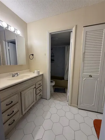 a spacious bathroom with a granite countertop sink and a mirror