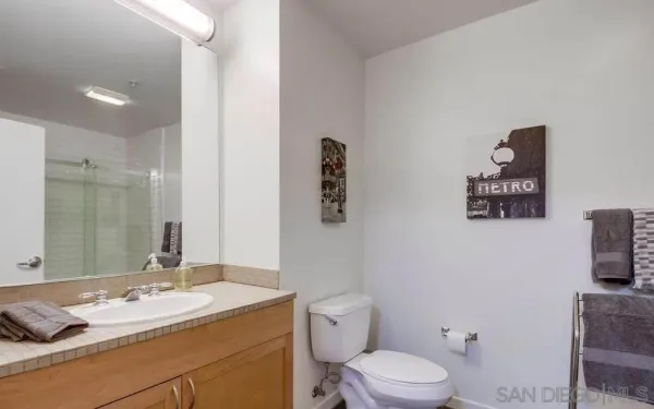a bathroom with a granite countertop sink mirror vanity and toilet