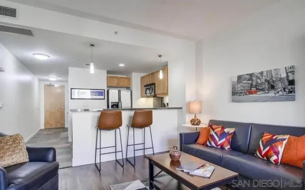 a living room with furniture and a dining table with wooden floor