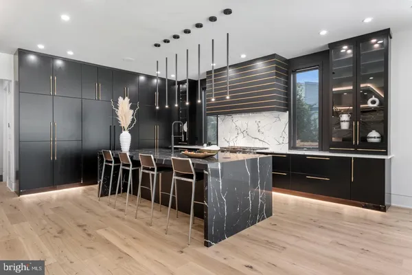 a kitchen with stainless steel appliances kitchen island granite countertop a refrigerator and a wooden floors