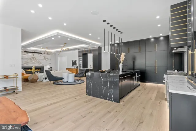 a kitchen with stainless steel appliances granite countertop a sink a stove and a wooden floors