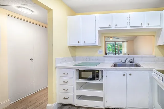 a kitchen with a sink cabinets and a window