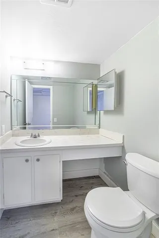 a bathroom with a toilet a sink and mirror