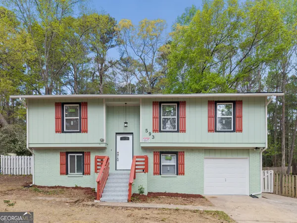 a front view of a house with a tree