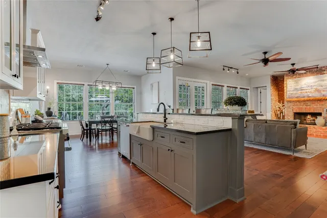 a kitchen with stainless steel appliances granite countertop wooden floors and white cabinets
