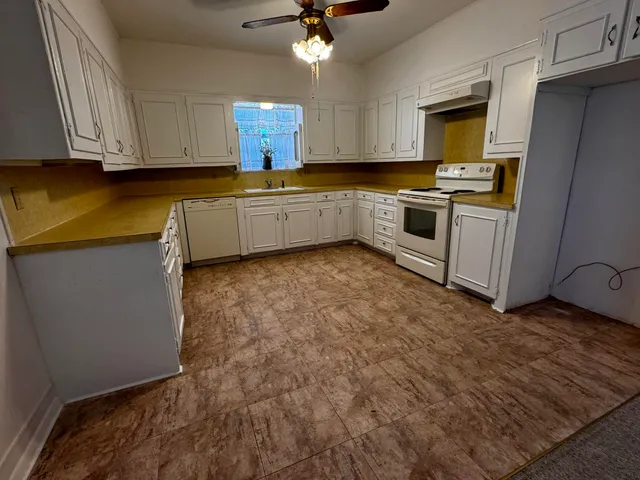 a view of a kitchen with wooden cabinet and a chandelier