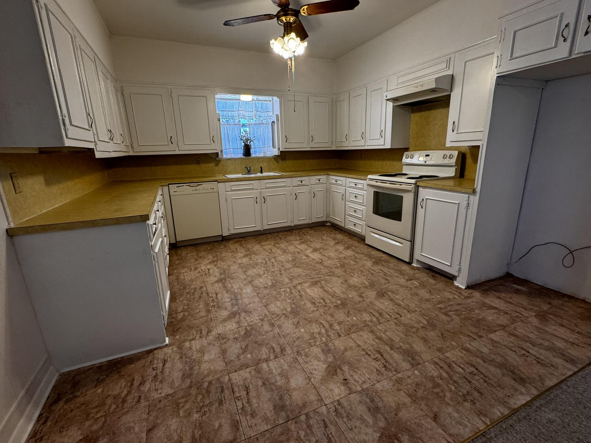 1209 Garland Plainview, TX 79072 - Photo 13 of 37 a kitchen with granite countertop a sink stainless steel appliances and cabinets