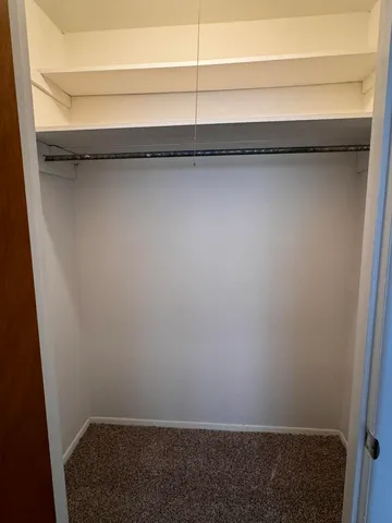 an empty room with windows and chandelier fan