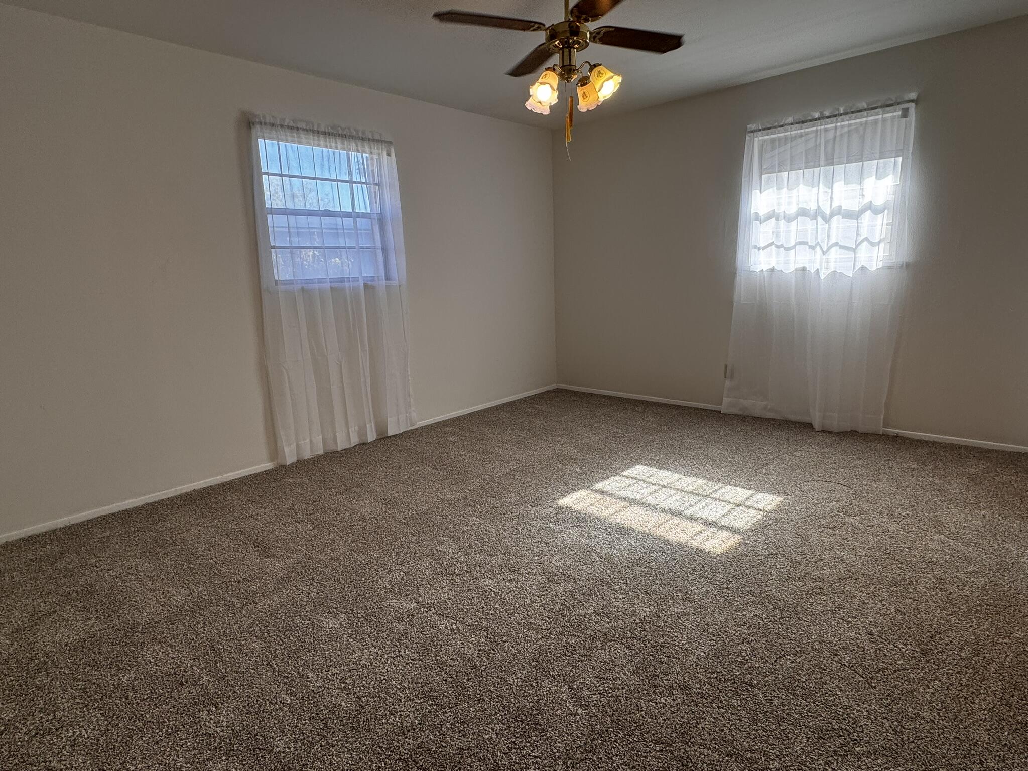 1209 Garland Plainview, TX 79072 - Photo 20 of 37 an empty room with windows and chandelier fan