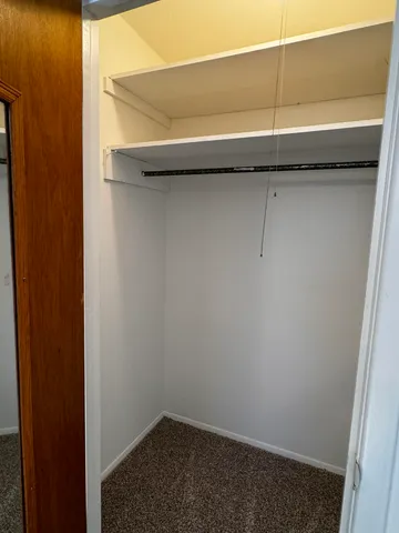 an empty room with windows and chandelier fan