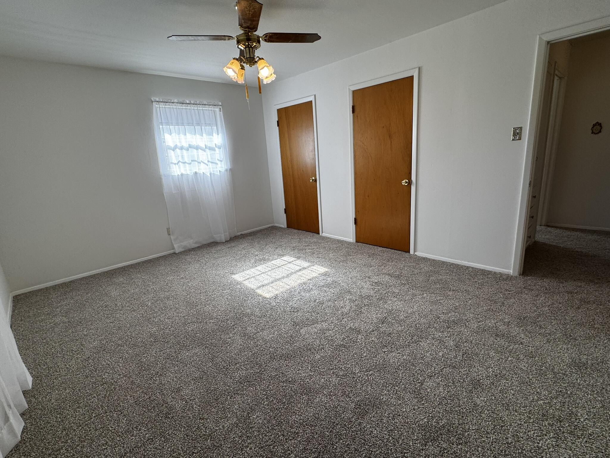1209 Garland Plainview, TX 79072 - Photo 22 of 37 an empty room with windows and chandelier fan
