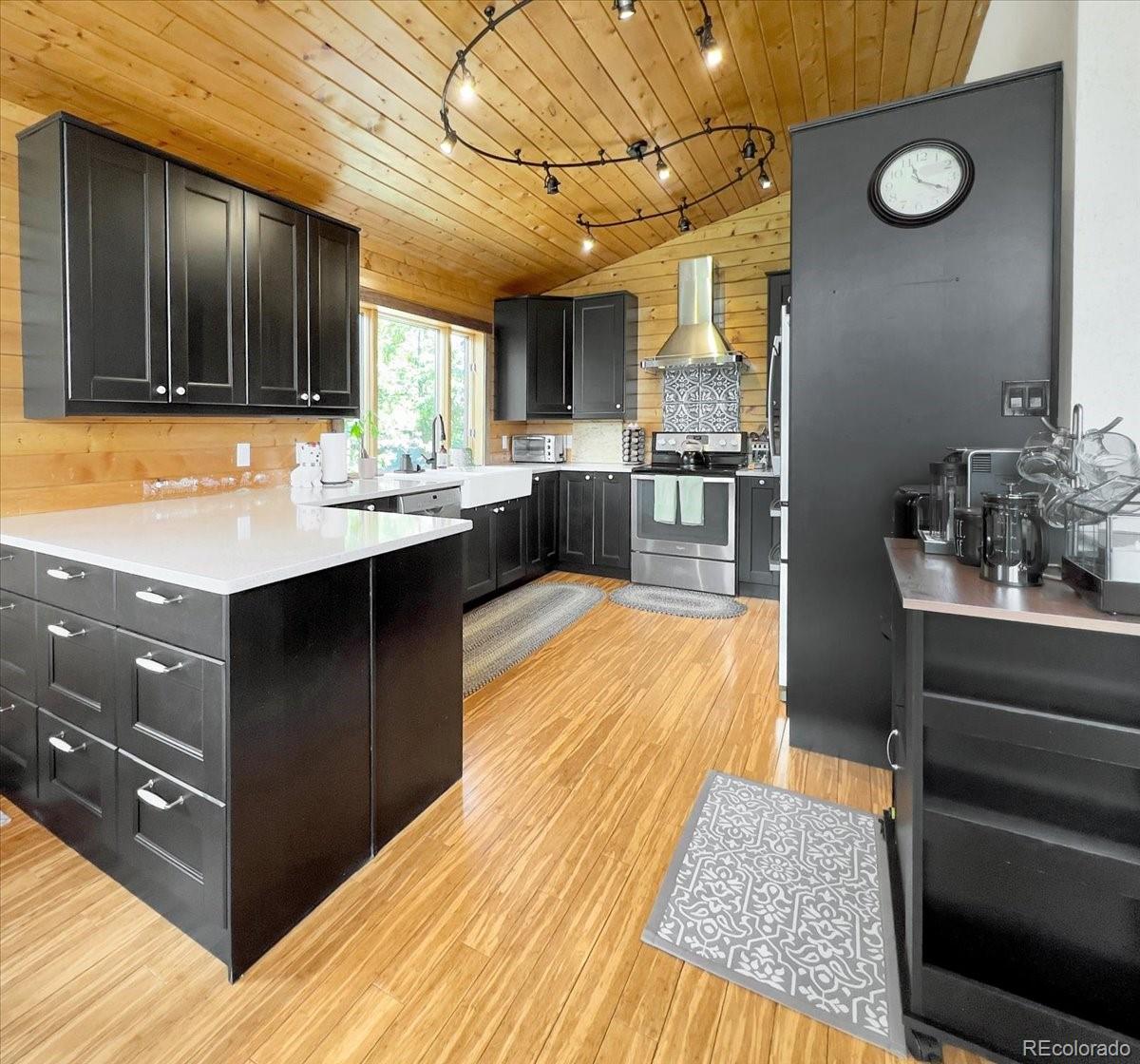 22155 Cook Lane Morrison, CO 80465 - Photo 5 of 28 a kitchen with stainless steel appliances kitchen island granite countertop a sink dishwasher stove and oven with wooden cabinets