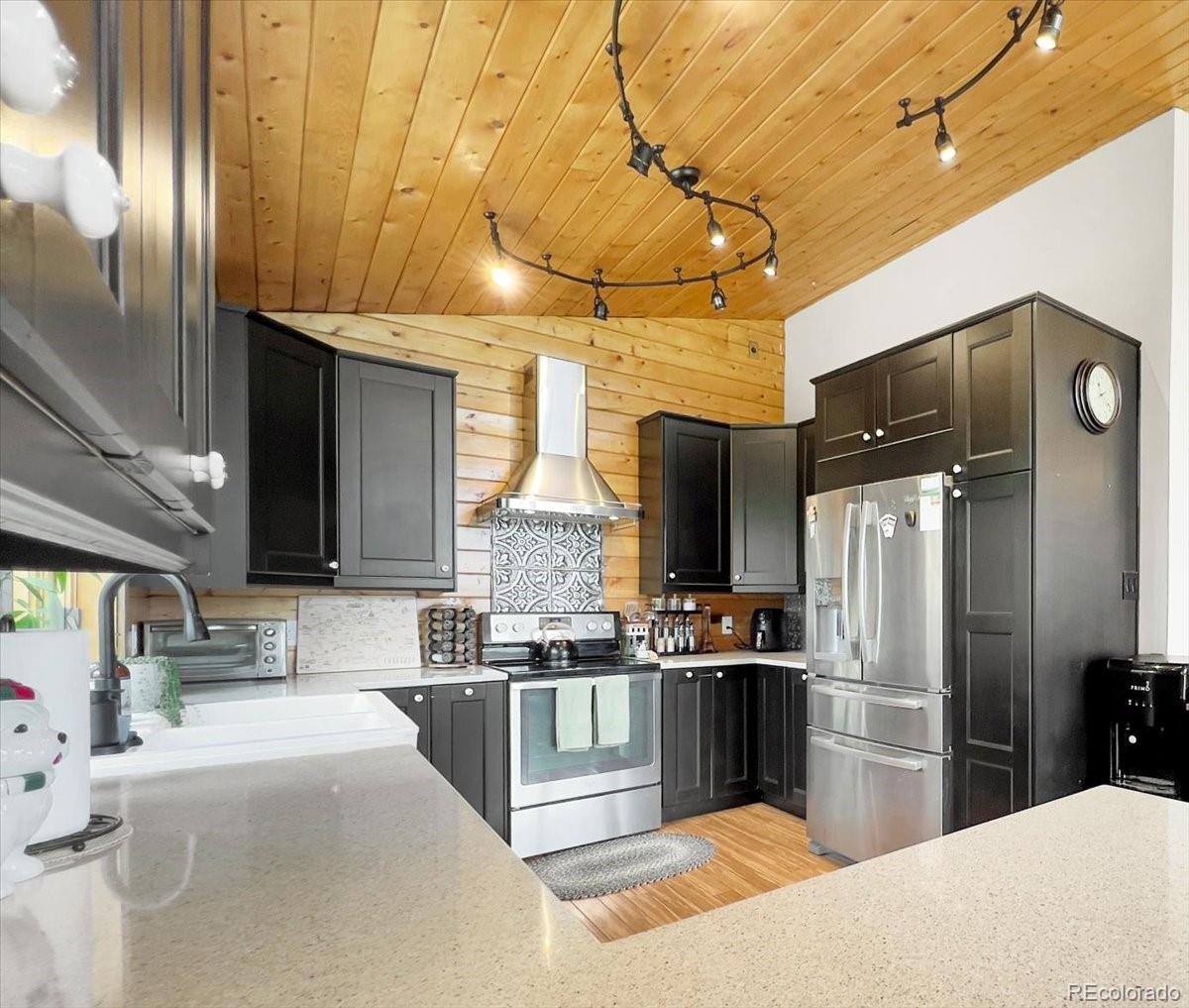 22155 Cook Lane Morrison, CO 80465 - Photo 6 of 28 a kitchen with stainless steel appliances kitchen island granite countertop a refrigerator and a sink